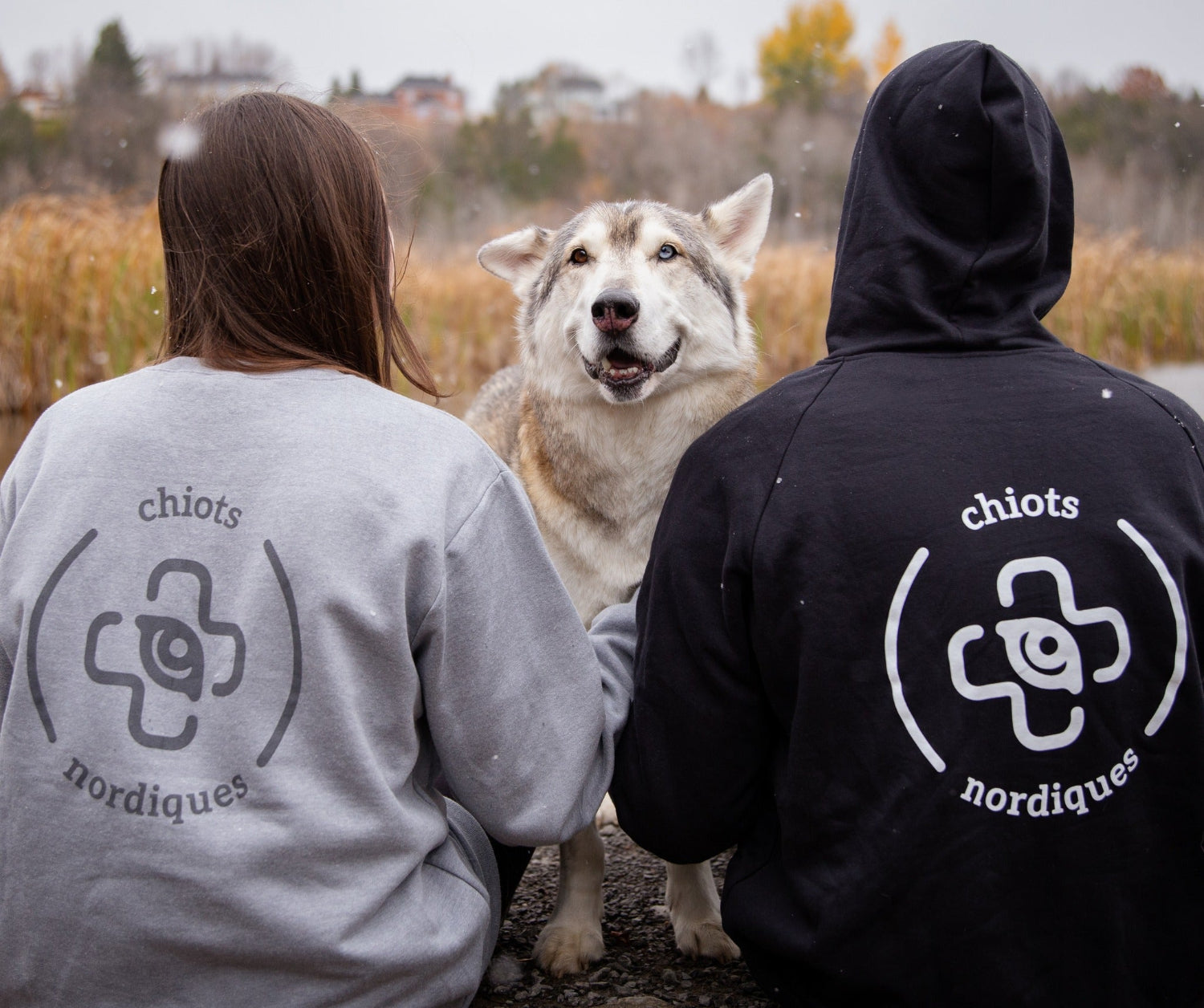 Deux personne avec chandail de chiots nordique, une fondation de rescue dog pour démontrer notre programme de don